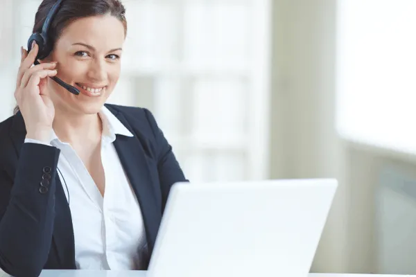 Call center representative wearing a headset at a laptop